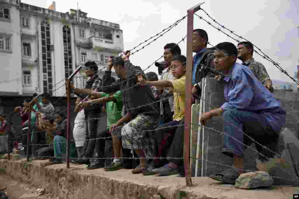 Locals gather to a rescue operation at the site of a budget hotel that collapsed in Saturday’s earthquake, in Kalanki neighborhood of Kathmandu, Nepal.