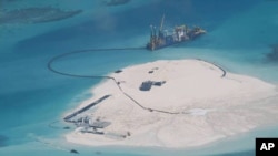 A Chinese vessel, top center, is used to expand structures and land on the Johnson Reef, called Mabini by the Philippines and Chigua by China, at the Spratly Islands in the South China Sea, Philippines. 