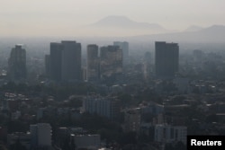 Buildings and houses stand shrouded in smog as authorities ordered traffic restrictions due to air pollution in Mexico City, Mexico, March 7, 2024. (REUTERS/Henry Romero)