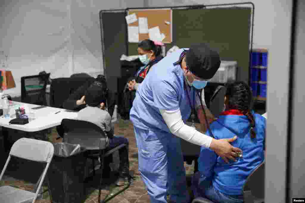 Una joven migrante pasa por un chequeo médico antes de entrar al área de admisión.