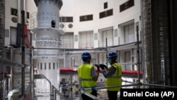 Workers speak together inside the ITER Tokamak machine in Saint-Paul-Lez-Durance, France, Thursday, Sept. 9, 2021.