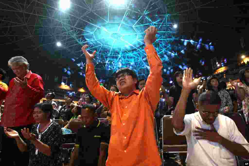 印度尼西亚人12月24日在印尼东爪哇的一个圣诞夜教堂活动中祈祷