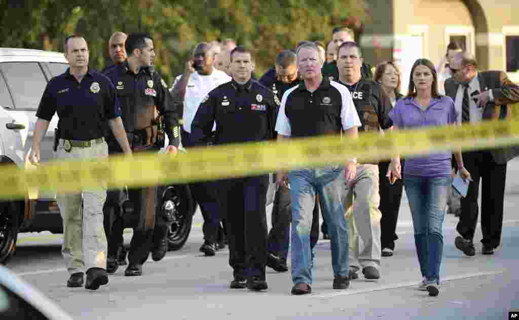 Orlando Mayor Buddy Dyer, center right, and Orlando Police Chief John Mina, center left, arrive to a news conference after a fatal shooting at Pulse Orlando nightclub in Orlando, Fla., June 12, 2016.