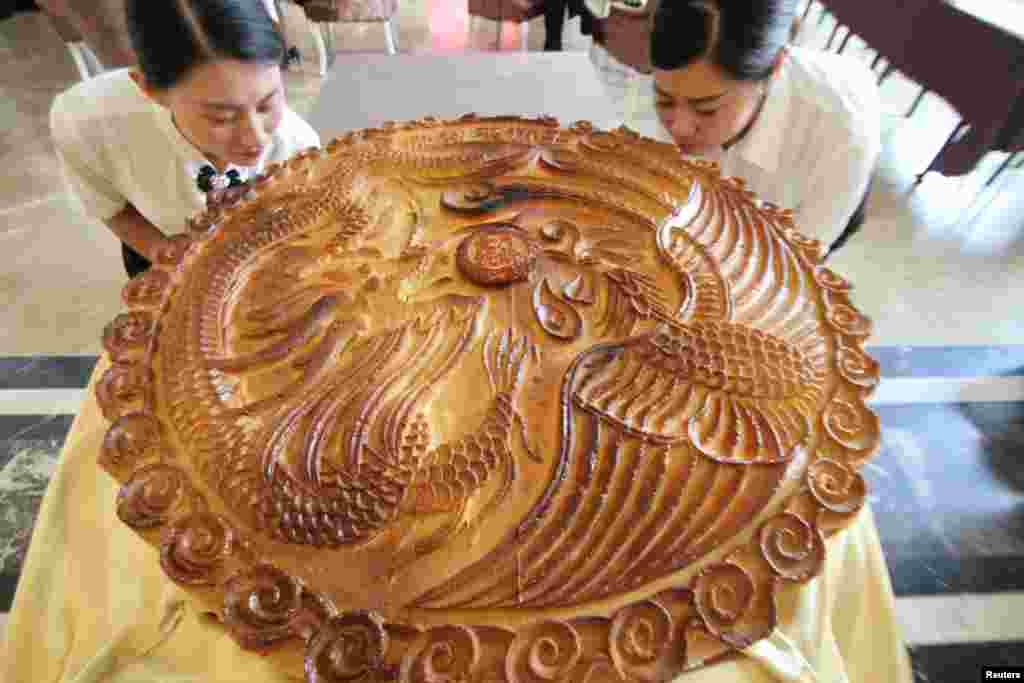 Para juru masak berpose dengan kue bulan raksasa pada festival menyambut Musim Gugur di Binzhou, Shandong, China.