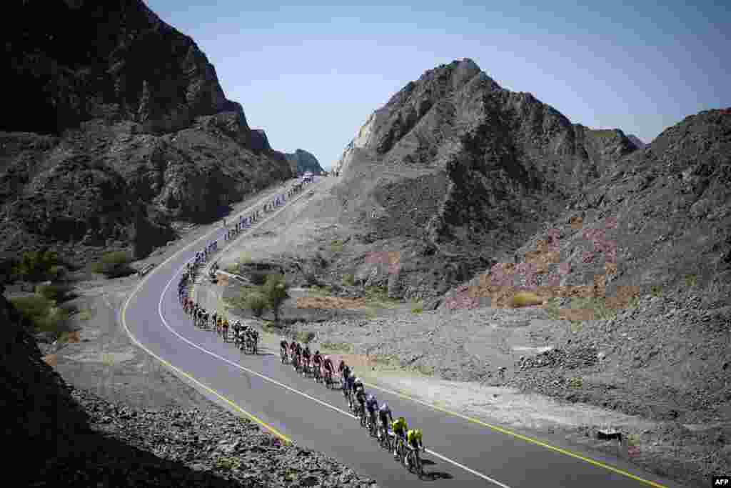 The pack rides during the fourth stage of the Tour of Oman cycling race from Oman Across Ages Museum to Oman Convention Center. (Photo by Loic VENANCE / AFP)