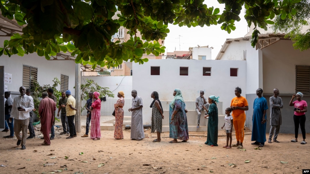 Eleitores aguardam na fila à porta de uma mesa de voto em Dakar, a 17 de novembro de 2024,