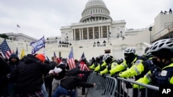 Simpatizantes del presidente Donald Trump tratan de abrirse paso a la fuerza al Capitolio en Washington, el 6 de enero de 2021. 