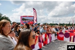 Spectators wait for the arrival of the Olympic flame as part of the Olympic torch relay at the Esplanade du Champs de Mars in Lille, northern France, on July 2, 2024, ahead of the Paris 2024 Olympic Games. (Photo by Sameer Al-Doumy / AFP)
