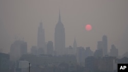 The sun rises over a hazy New York City skyline as seen from Jersey City, N.J., Wednesday, June 7, 2023. Intense Canadian wildfires are blanketing the northeastern U.S. in a dystopian haze, turning the air acrid, the sky yellowish gray and prompting warnings for vulnerable populations to stay inside. (AP Photo/Seth Wenig)