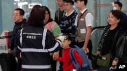 港府提升应对神秘肺炎的级别，2020年1月4日在香港机场检测旅客体温。