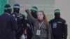 La soldado israelí Agam Berger saluda a la multitud junto a militantes enmascarados de la Jihad Islámica mientras es entregada a la Cruz Roja en el campo de refugiados de Jabalia en la ciudad de Gaza, el 30 de enero de 2025.
