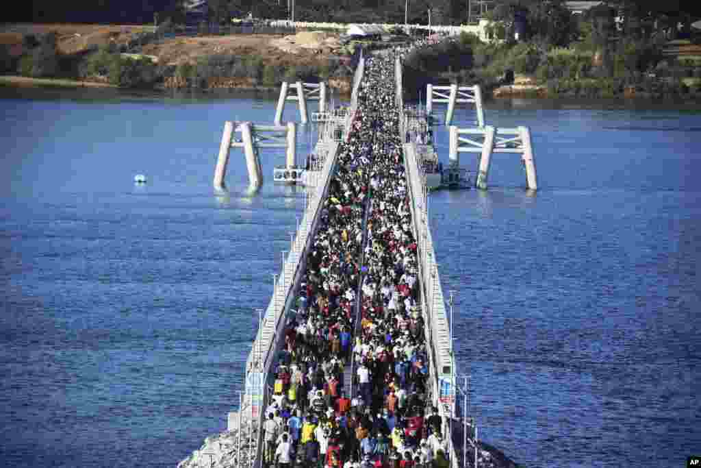 Hundreds of Mombasa residents cross the recently constructed floating foot bridge from Mombasa's Likoni mainland to the Mombasa Island, Kenya.