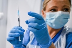 Paula McMahon prepares a shot of the Pfizer-BioNTech COVID-19 vaccine, as the mass public vaccination program gets underway, at the NHS Louisa Jordan Hospital in Glasgow, Scotland, Dec. 8, 2020.