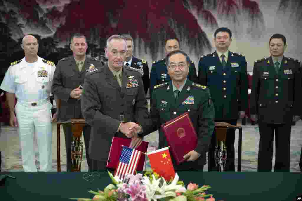 美军参联会主席邓福德上将(前左)与中国中央军委联合参谋部参谋长房峰辉在北京签署协议后握手 (2017年8月15日)。邓福德曾说, 两国之间“有很多棘手的问题”需要解决。