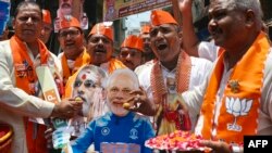 印度总理纳伦德拉·莫迪(Narendra Modi)的支持者祝贺他在印度大选初步计票中明显胜出。（法新社） 
