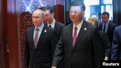 Russia's President Vladimir Putin (L) with Chinese President Xi Jinping 