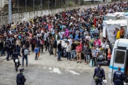 Refugees and migrants wait to be transfered from the island of Lesbos to the Greek mainland, May 3, 2020.