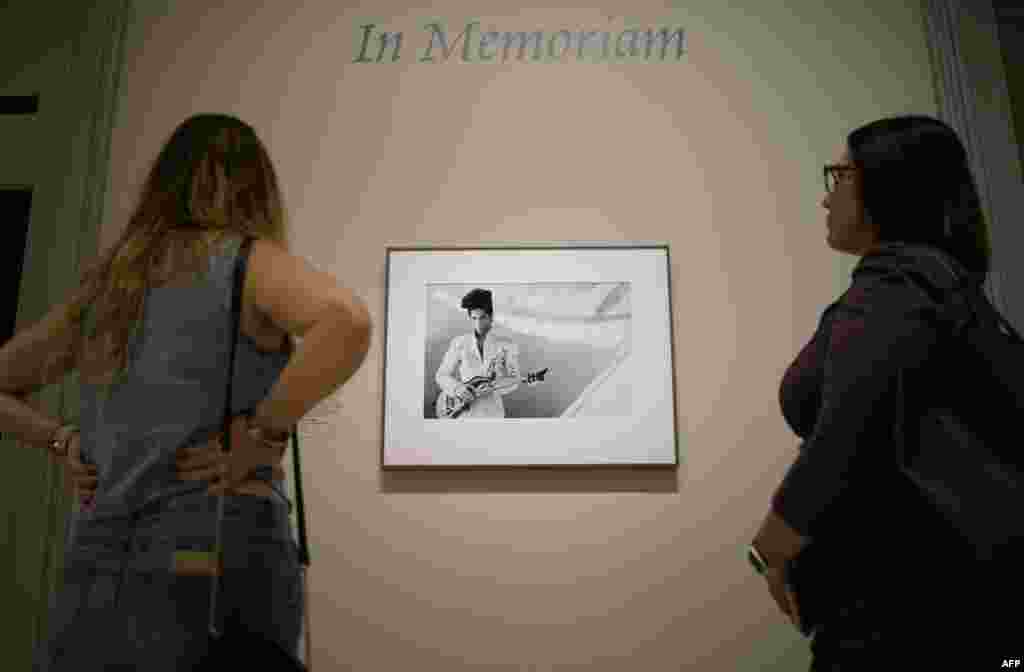 Visitors look at a 1993 photograph of musician Prince by Lynn Goldsmith at the Smithsonian’s National Portrait Gallery in Washington, D.C., April 22, 2016. . The Smithsonian’s National Portrait Gallery is recognizing the life and accomplishments of Prince with the photograph by Goldsmith. It will be installed in the museum’s In Memoriam space.