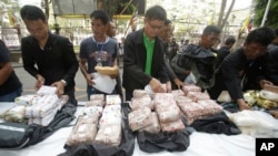Thai policemen display drugs during a press conference in Bangkok, Thailand on March 24, 2016. They had seized 226 kilograms of crystalline methamphetamine and 8 kilograms of heroin. Thai police have arrested 15 Malaysians.