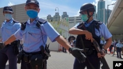 资料照片：当香港首位被控涉嫌违反国安法的唐英杰坐着轮椅被押解至法院时港警戒备。（2020年7月6日）
