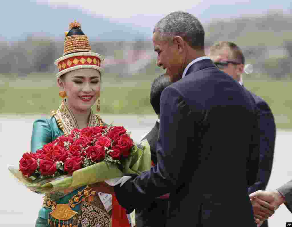 Presiden AS Barack Obama menerima bunga saat tiba di Bandar Udara Internasional Luang Prabang di Laos (7/9). (AP/Carolyn Kaster)