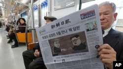 一名乘客在韩国首尔地铁中阅读朝鲜日报，该报头条报道计划中的美国总统川普与朝鲜领导人金正恩的首脑会谈。（2018年3月10日）